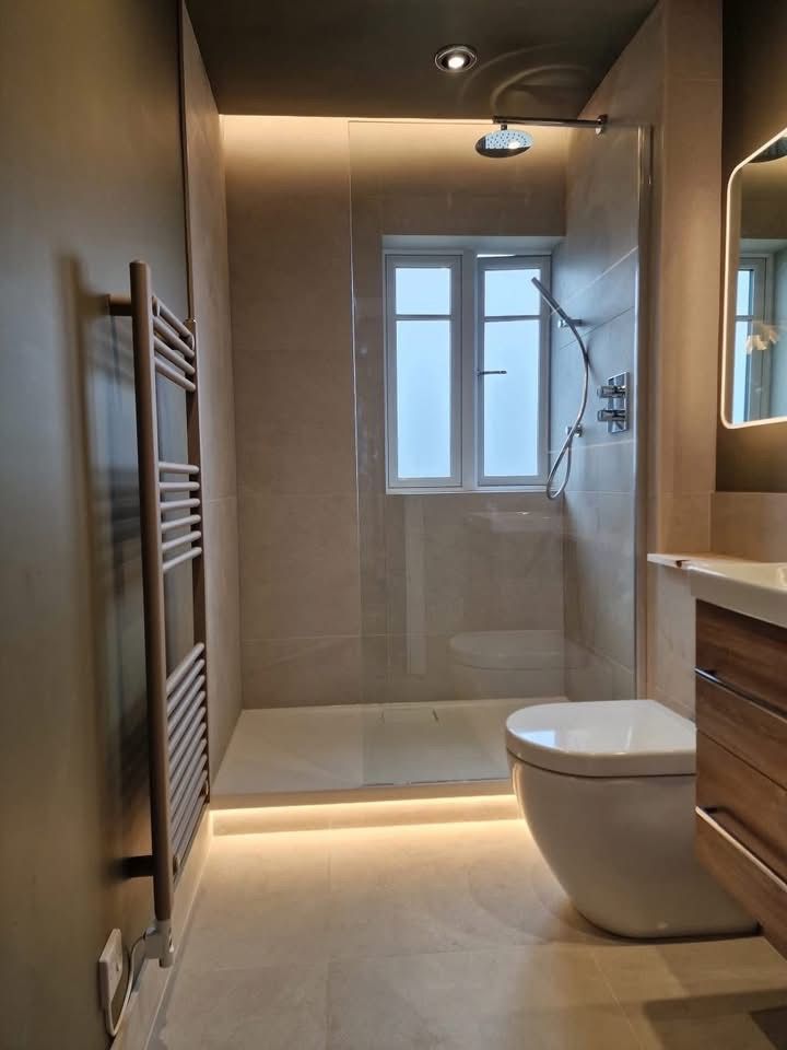 Walk-in shower with recessed lighting and heated towel rail