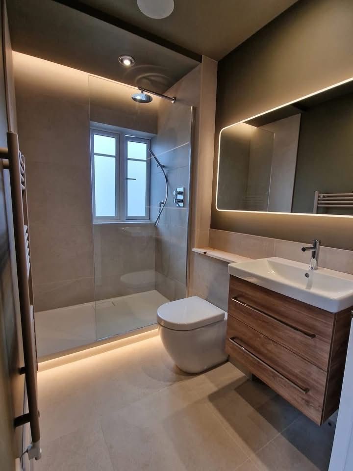 Bathroom with backlit LED mirror, shower downlight and plinth lighting